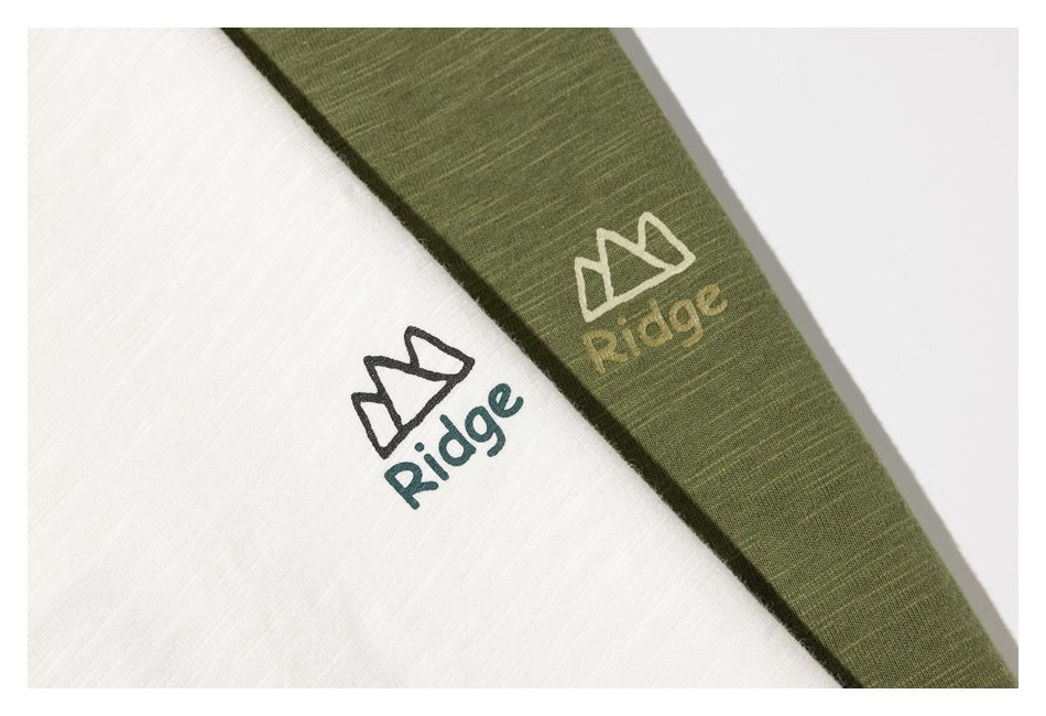 Close-up of white and olive green fabric with contrasting mountain-style Ridge logos.
