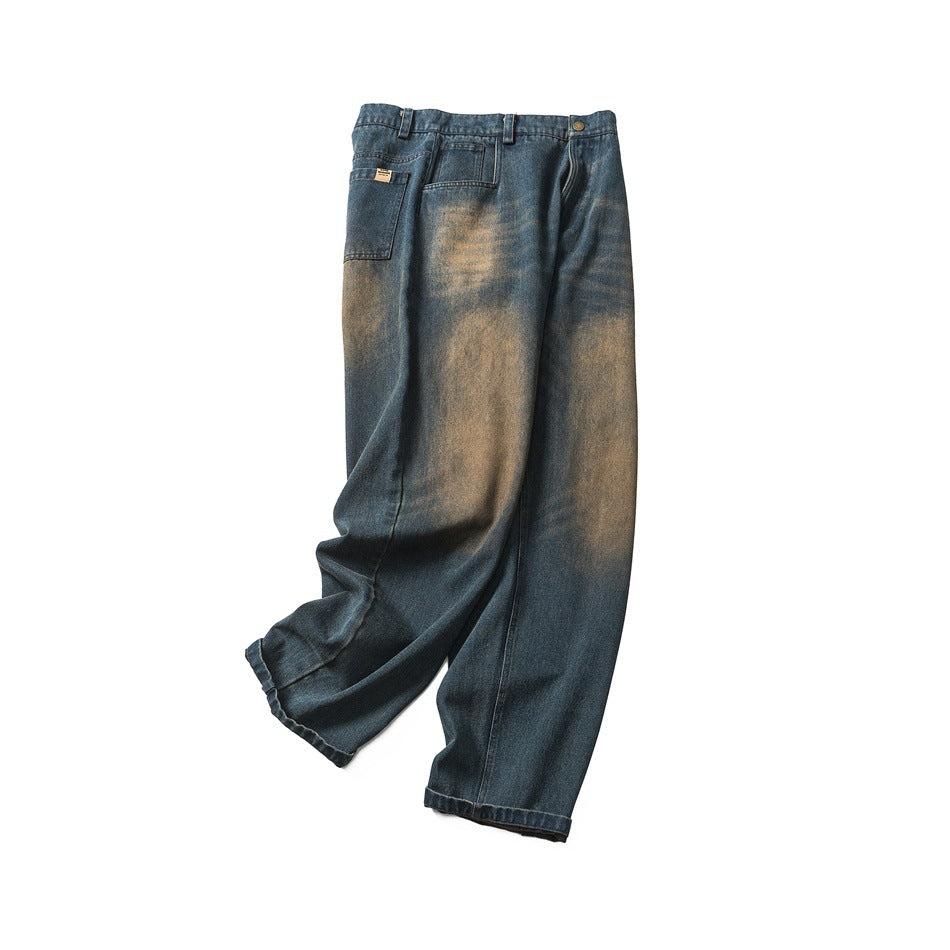 Full view of loose, wide-leg blue jeans with tan fading, arranged against a white background.