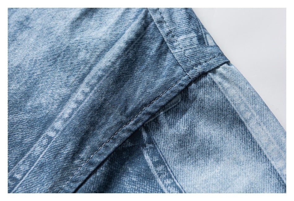 Close-up of blue washed shirt fabric and a stitched seam at the sleeve area.