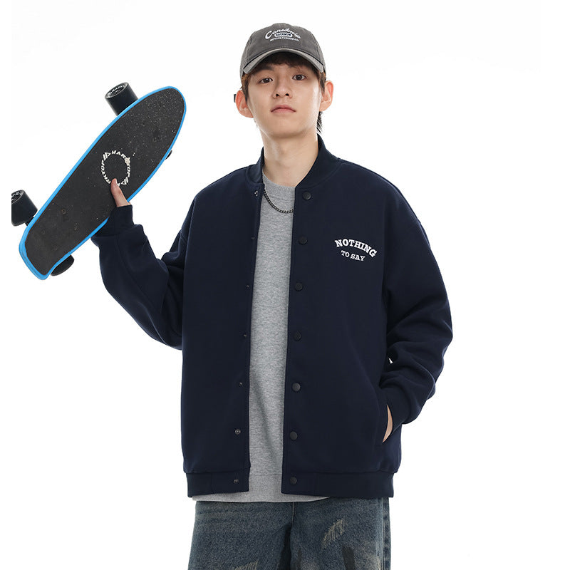 Model wearing a navy snap-front varsity jacket with white chest lettering and holding a skateboard.