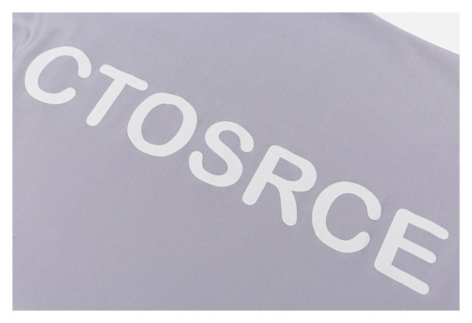Close-up of large white lettering printed diagonally across lavender-gray fabric.
