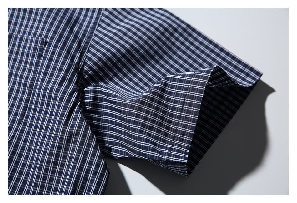 Close-up of a navy-and-white plaid shirt sleeve with a wide cuff.