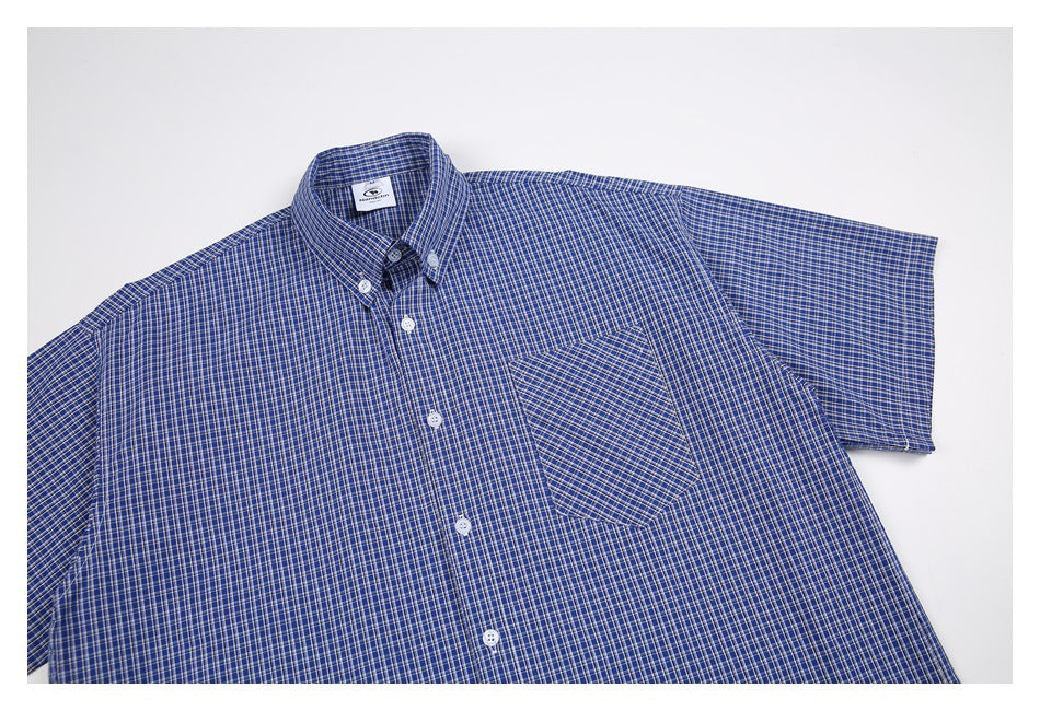 Flat lay of a blue short-sleeve button-down shirt with a fine check pattern and chest pocket.