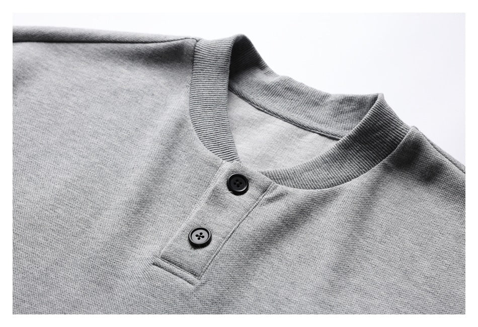 Close-up of a heather-gray shirt's ribbed crew neckline and two-button Henley placket.