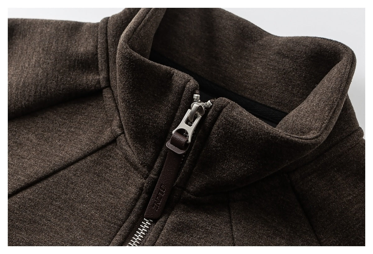 Close-up of a dark brown coat’s raised collar and silver zipper with a leather pull tab.