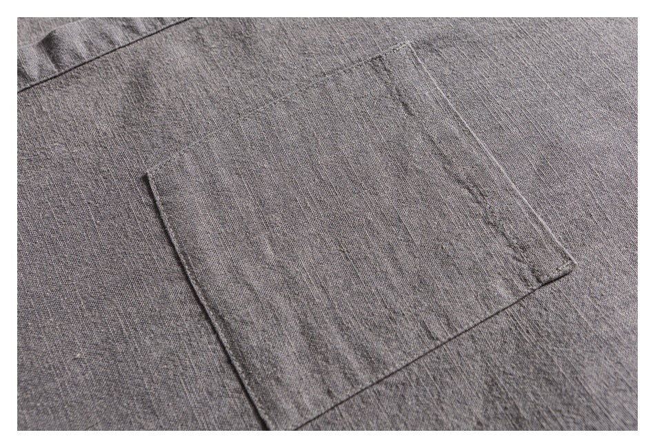 Close-up of a rectangular chest pocket on textured gray shirt fabric.