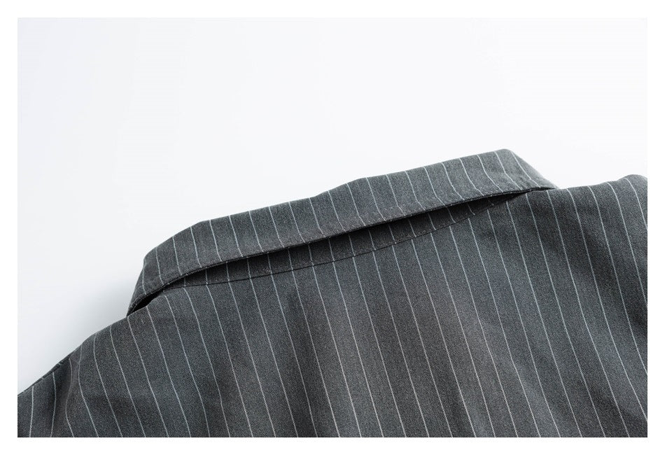 Close-up of the folded collar and pinstriped fabric of a charcoal garment.