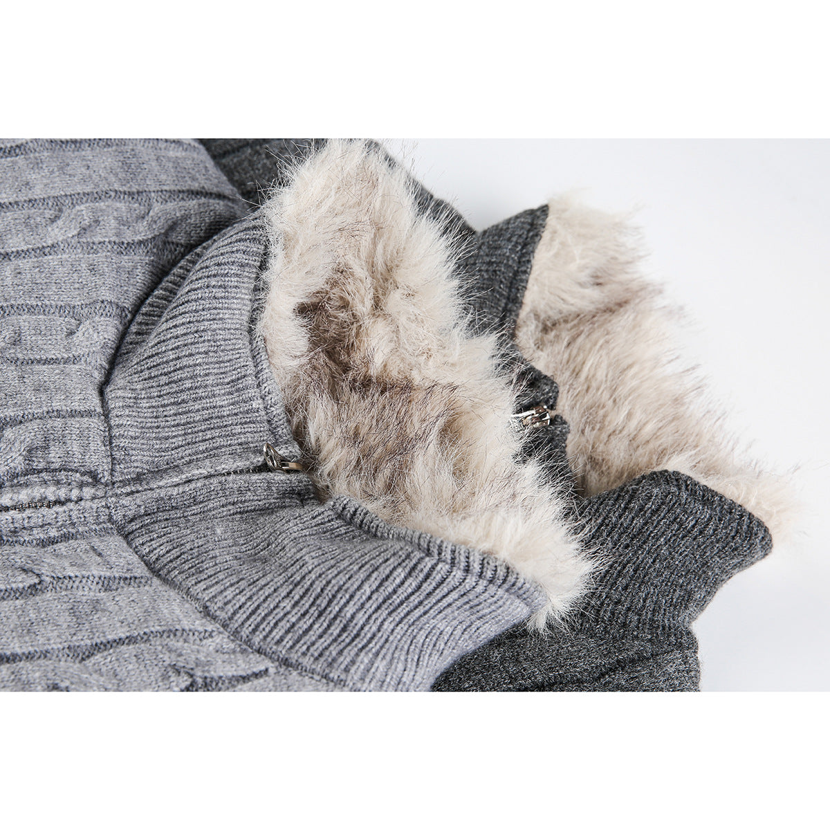 Close-up of gray cable-knit cardigan collars with cream faux-fur lining and zipper hardware.