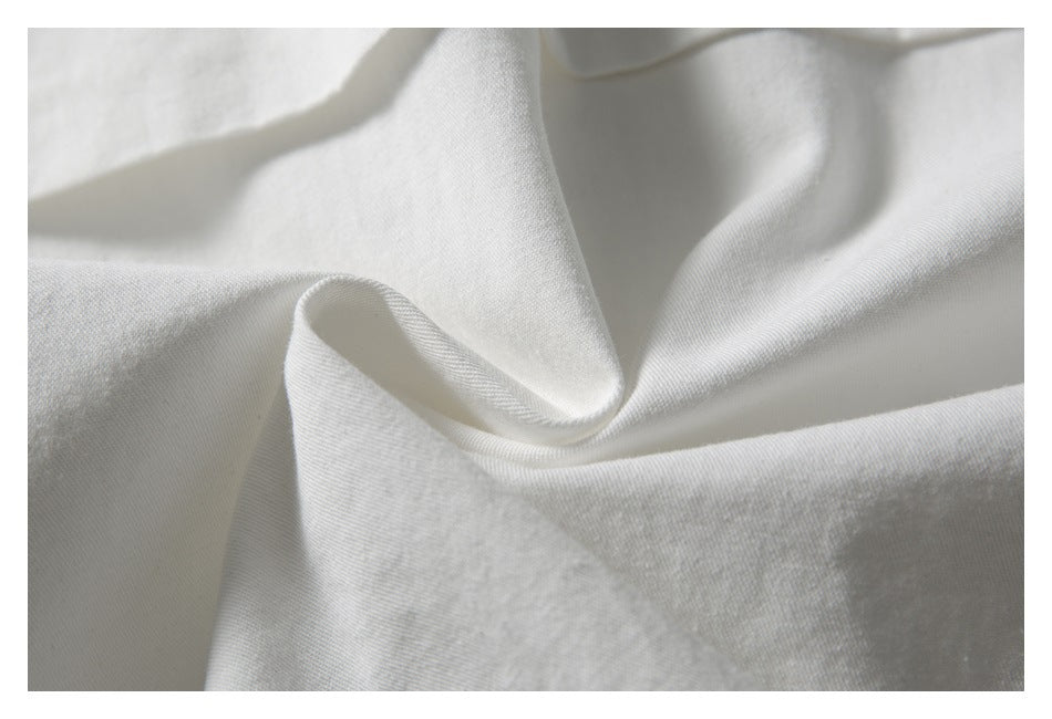 Close-up of white garment fabric arranged in soft folds.