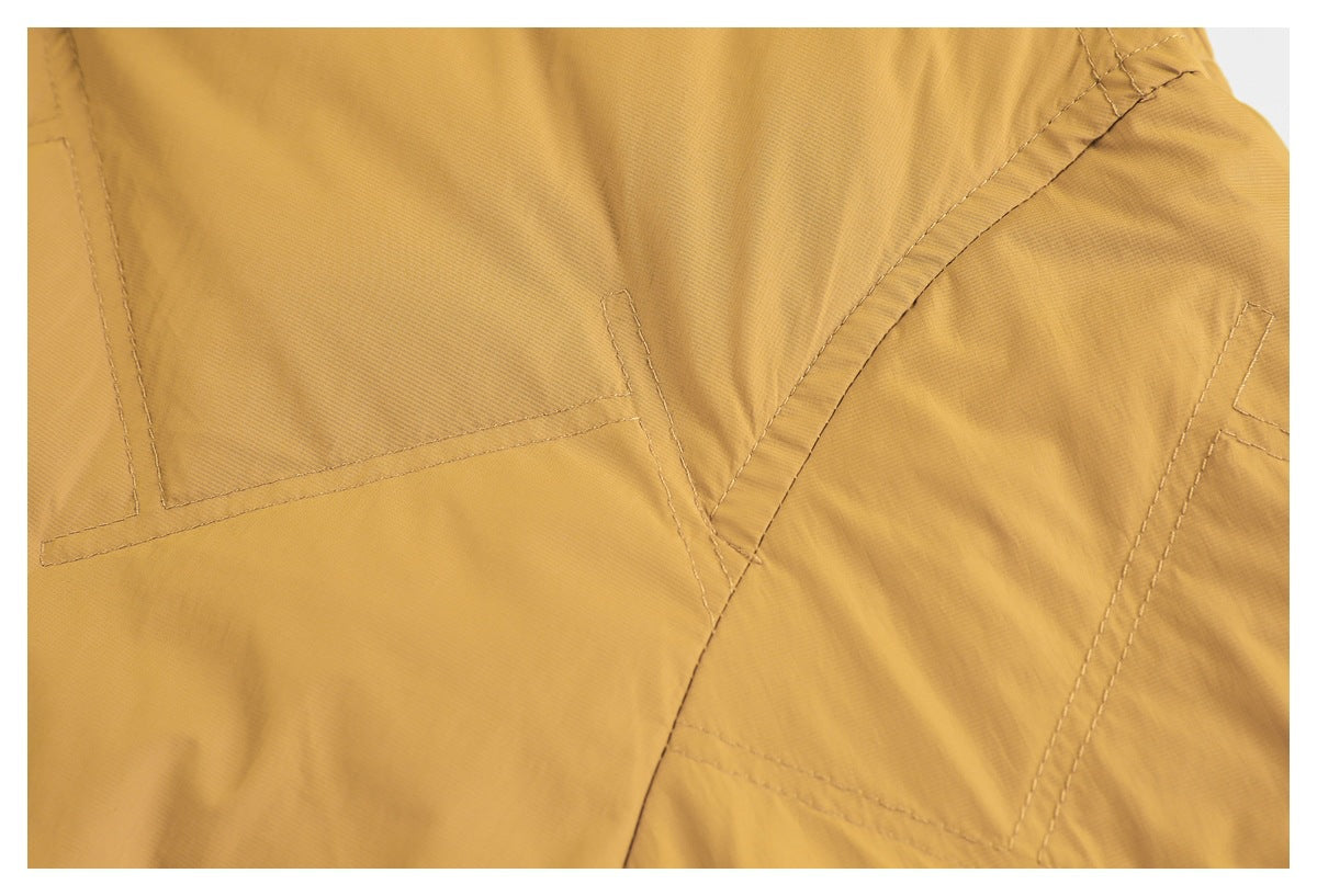 Close-up of mustard fabric with stitched geometric seam details.