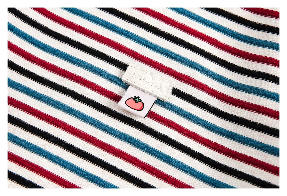 Close-up of the jacket’s red, teal, and black stripes with a small sewn tag featuring a tomato graphic.