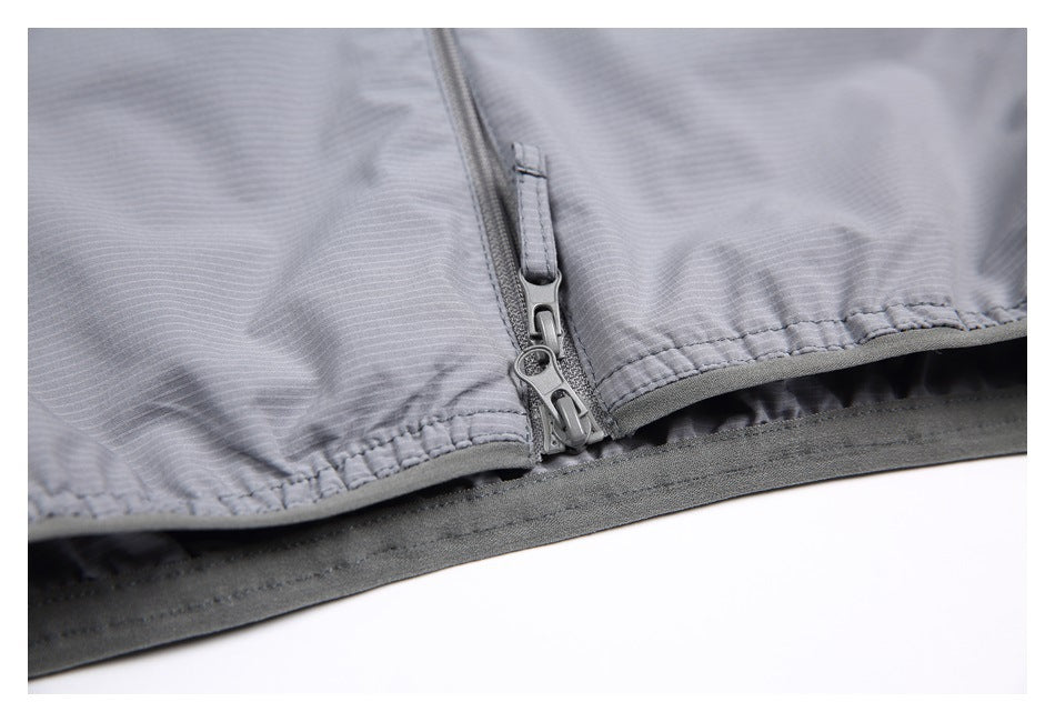 Close-up of a gray vest hem with a central zipper, gathered stitching, and dark edging.