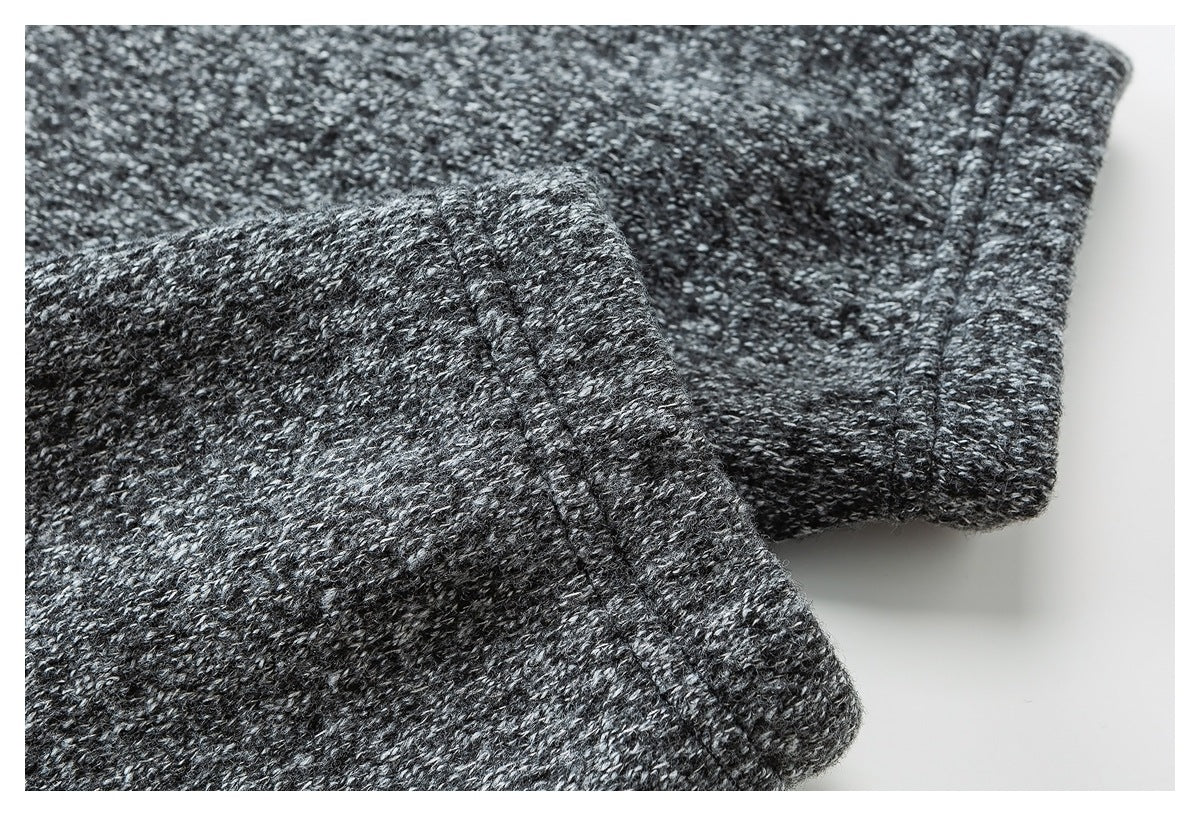 Close-up of a folded cuff and seam in charcoal marled knit fabric.
