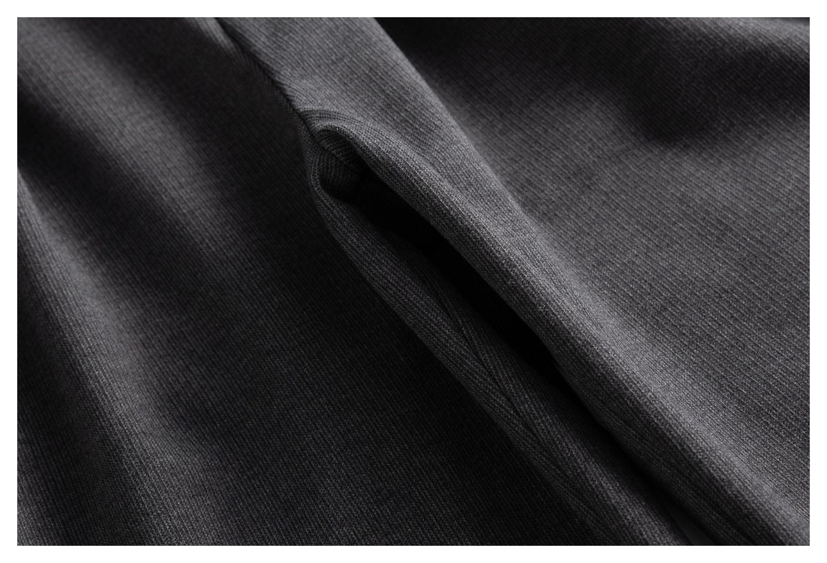 Close-up of charcoal gray trouser fabric with a narrow pocket opening.