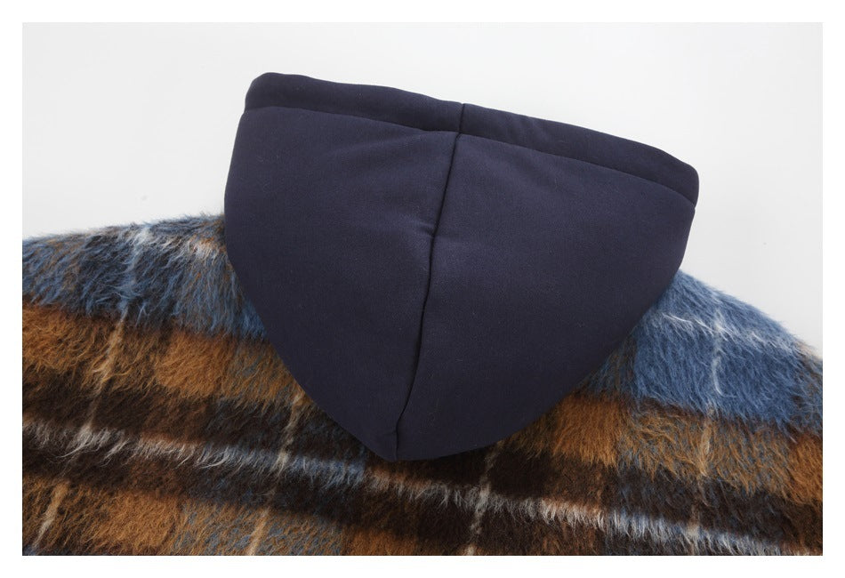 Close-up of a dark hood against a brown, blue, and gray fuzzy plaid garment.