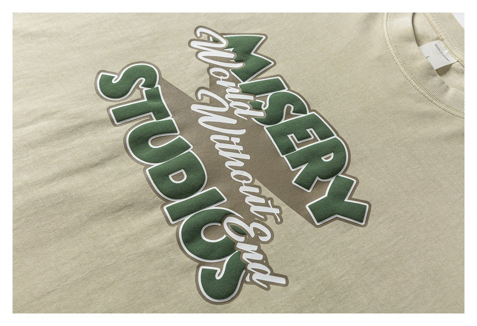 Close-up of a cream T-shirt with a large green, white, and taupe chest graphic.