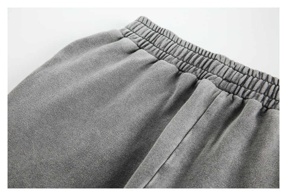 Close-up of gray pants showing the gathered elastic waistband and stitched seams.