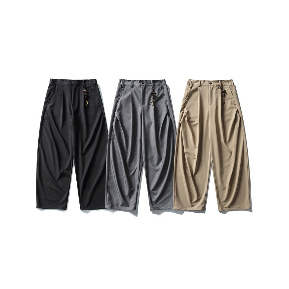 Three pairs of wide-leg trousers shown from the front in black, gray, and beige.