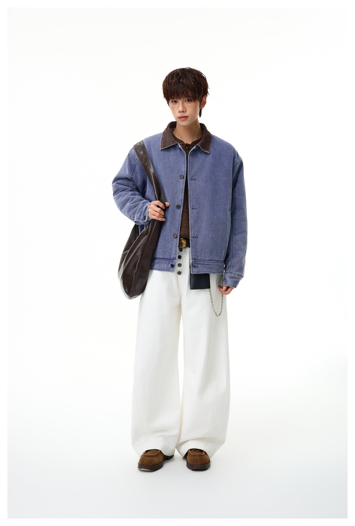 Full-length view of a model wearing a faded blue jacket with a brown collar and wide white trousers.