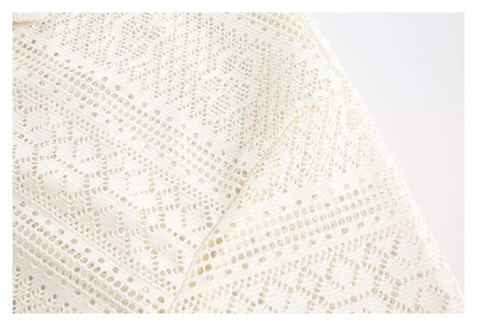 Close-up of the ivory lace shirt's sleeve seam and openwork pattern.