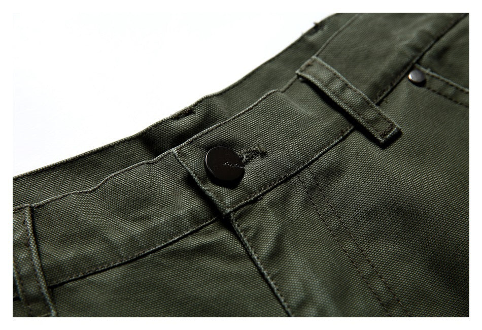 Close-up of the olive green trouser waistband, dark button, fly stitching, and belt loop.