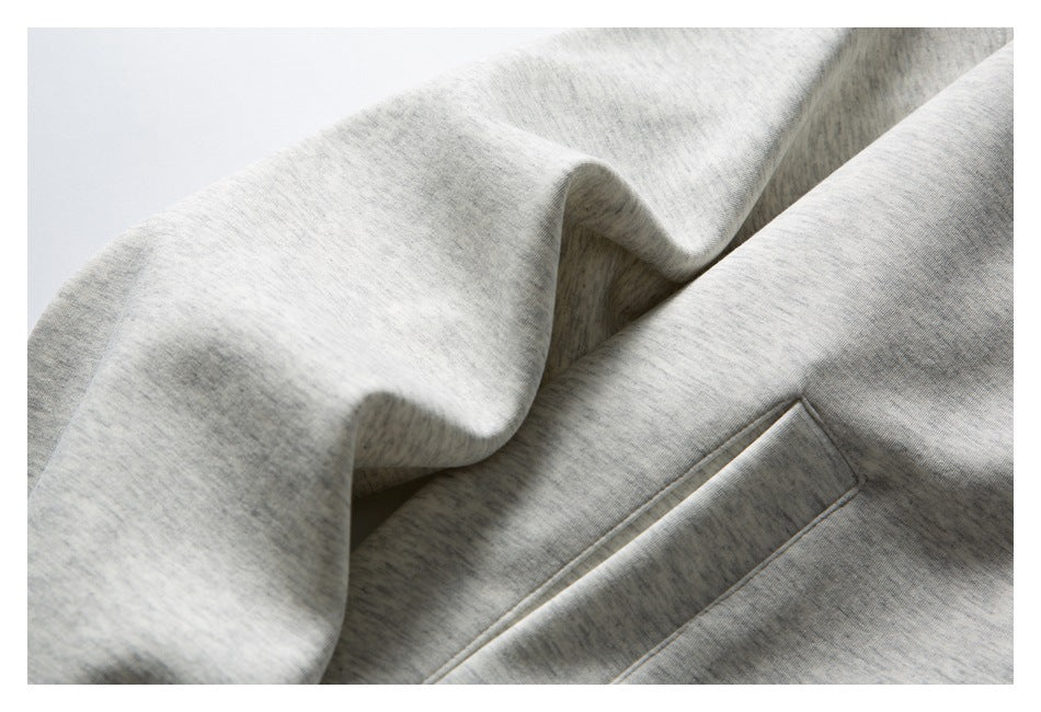 Close-up of the light gray marled sweatshirt fabric and angled front pocket opening.