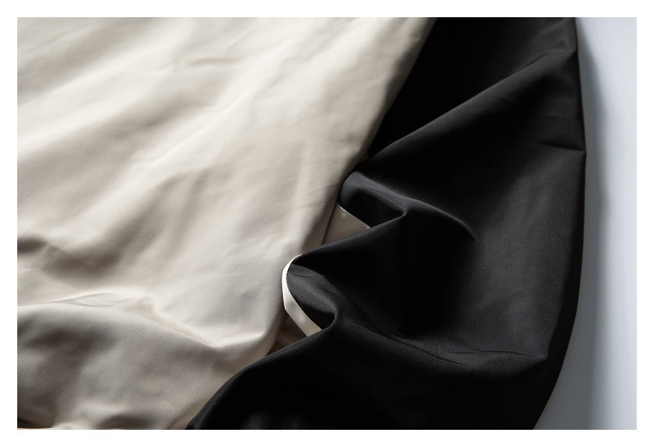 Close-up showing light beige jacket fabric beside a black contrasting panel.