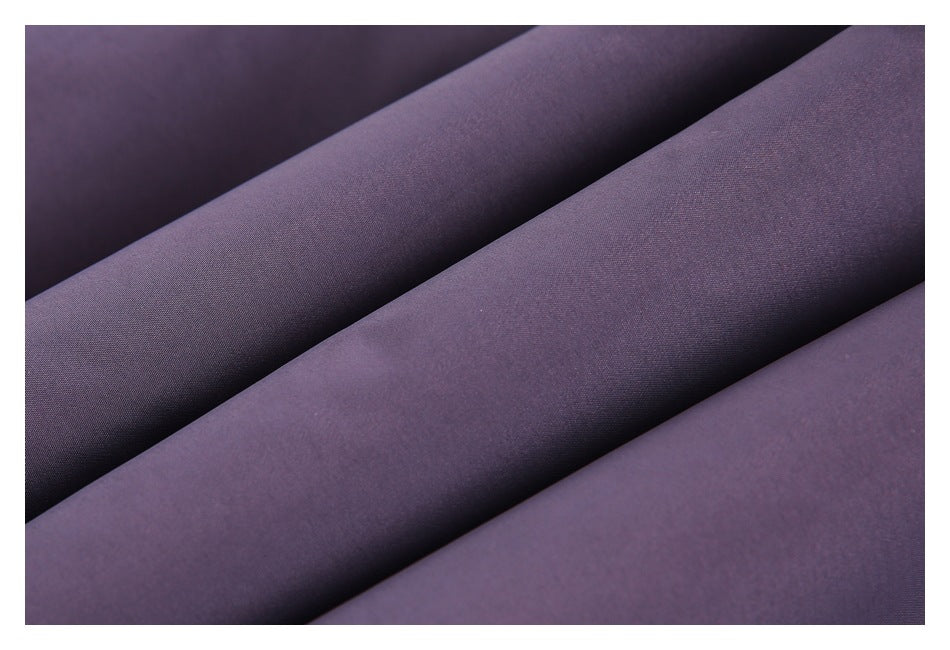 Close-up of dark purple fabric arranged in diagonal folds, showing its fine surface texture.