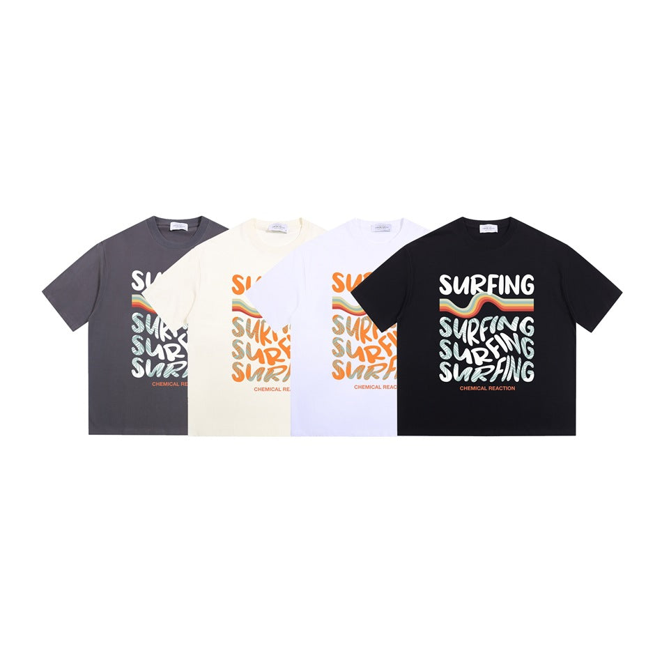 Four graphic T-shirts in charcoal gray, cream, white, and black, each with a Surfing print.