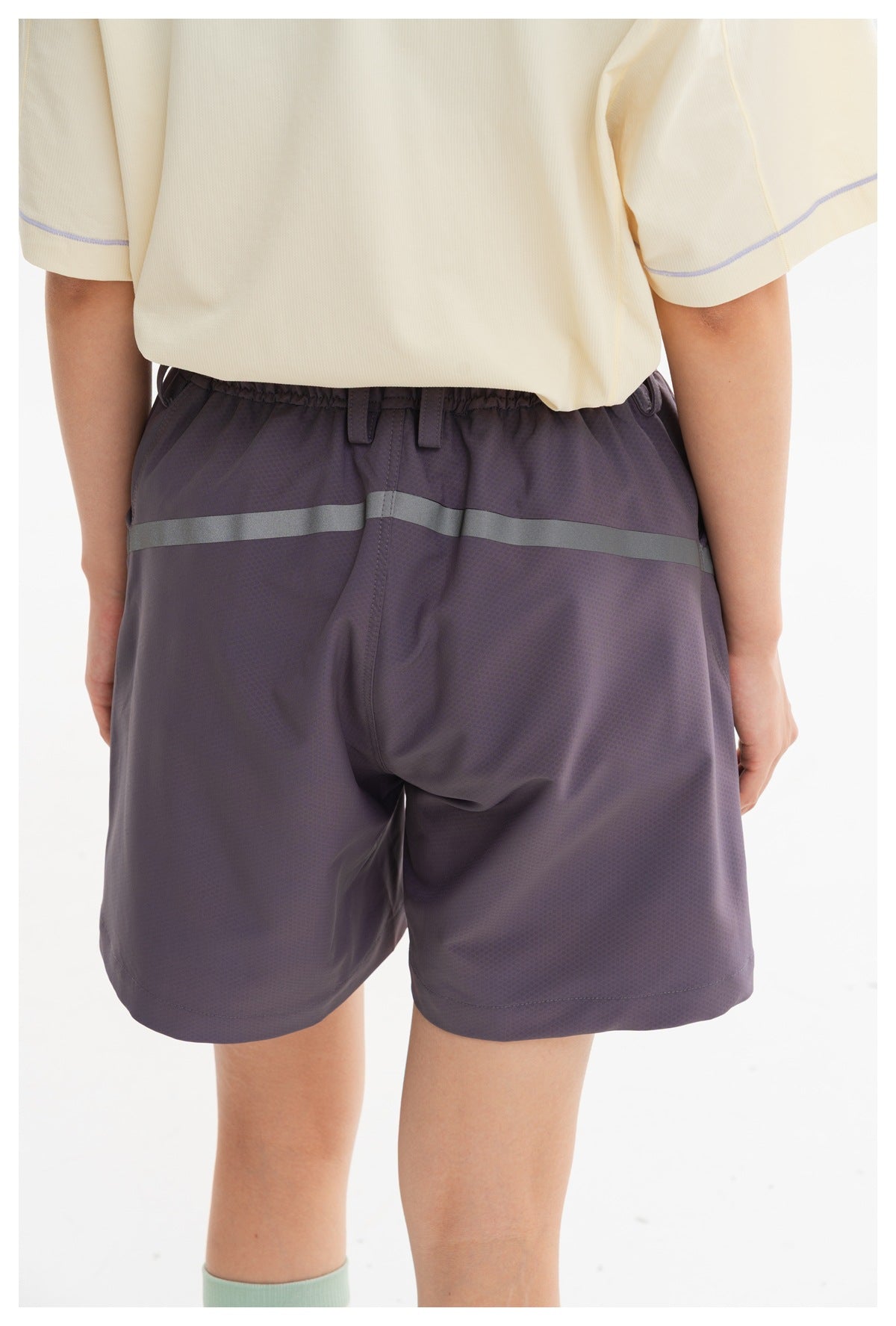 Close-up of the shorts' elastic back waistband, belt loops, and reflective stripe.