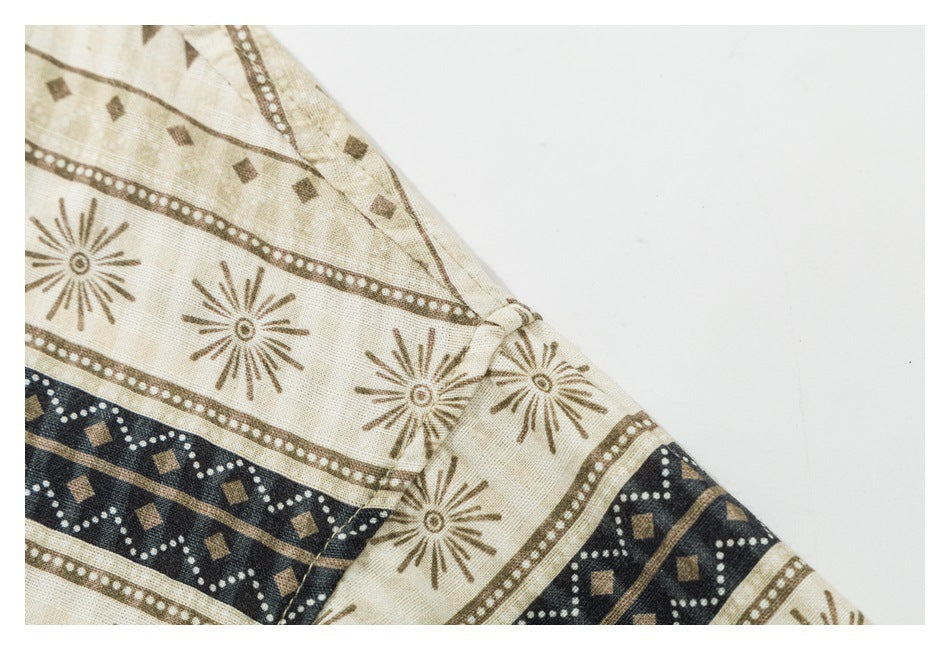 Close-up of a beige garment with brown sunburst motifs and a dark navy geometric band at a seam.