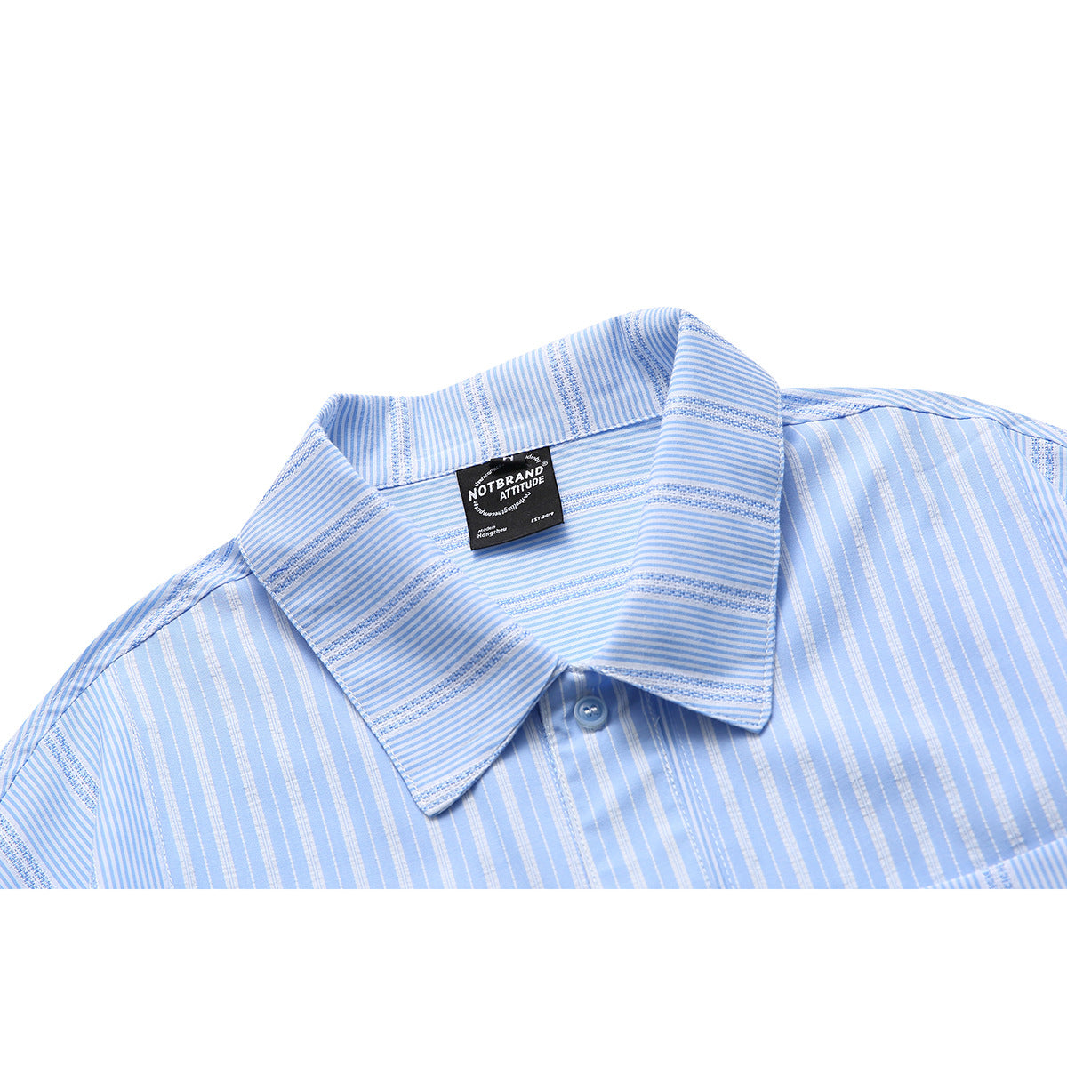 Close-up of a light blue striped shirt collar with a dark sewn-in neck label and blue button.