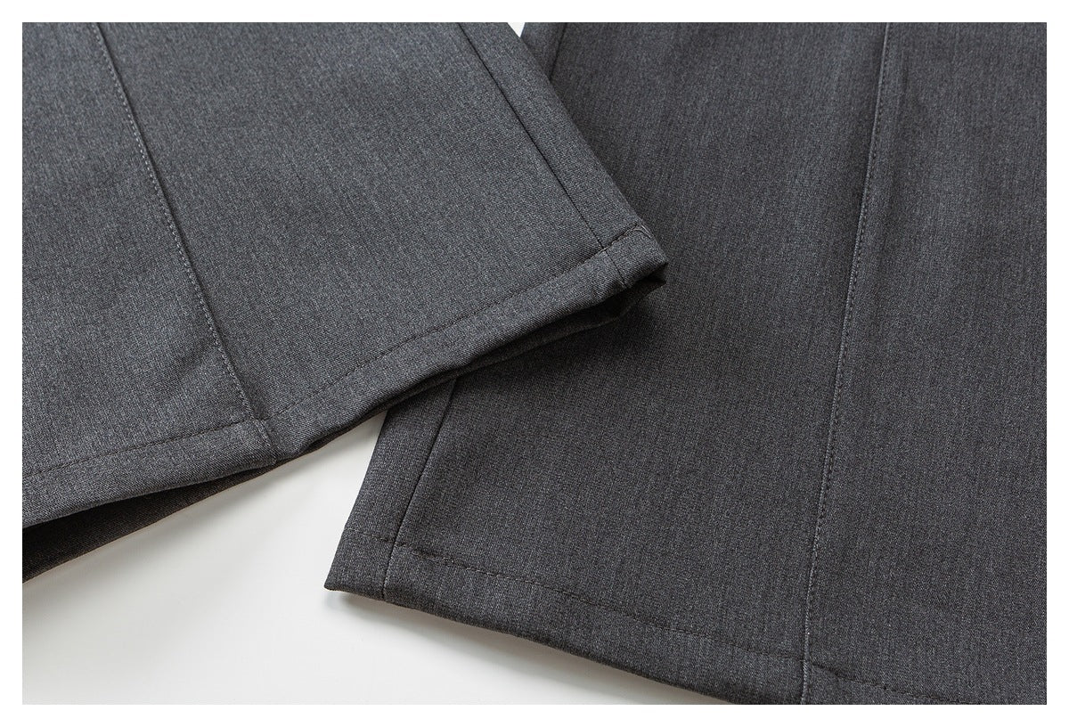 Close-up of charcoal gray pant legs showing stitched hems and a folded cuff on one leg.