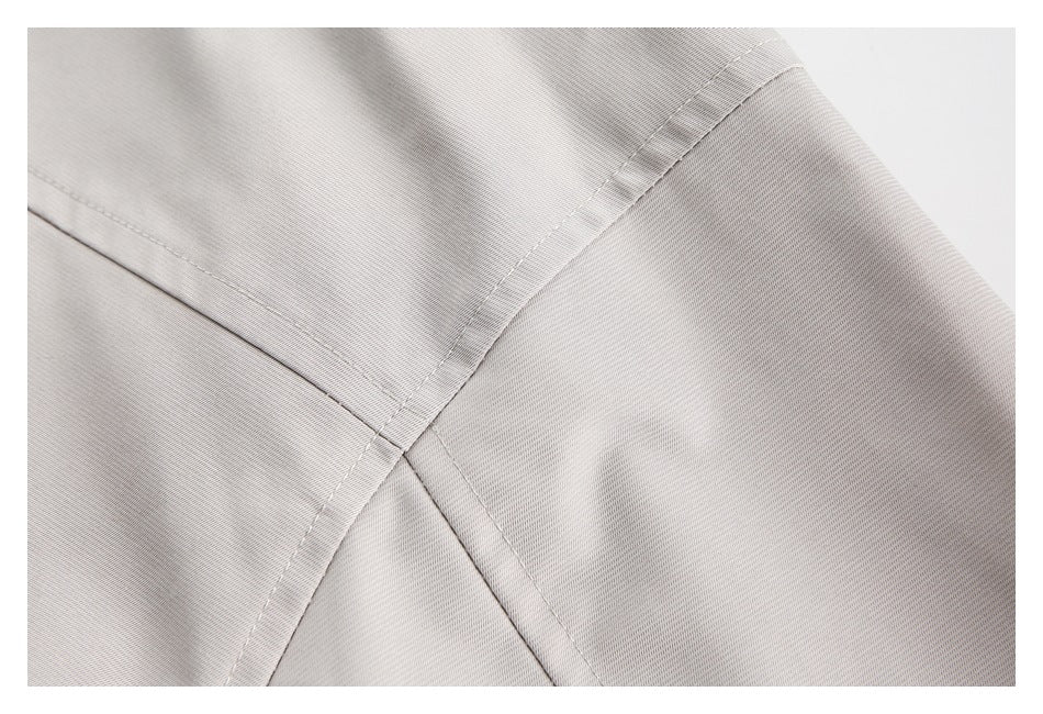 Close-up showing intersecting stitched seams on light gray apparel.