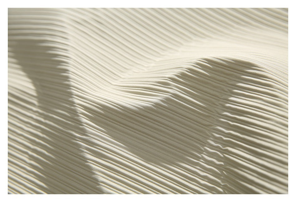 Close-up of ivory fabric with narrow raised vertical ribs and soft folds.