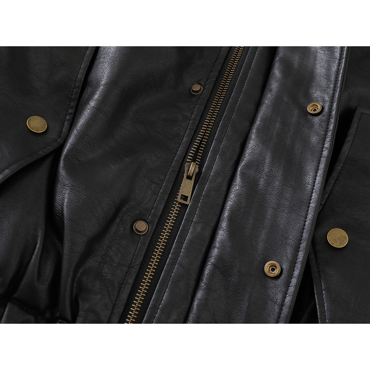 Close-up of a black jacket's front zipper, brass-tone snaps, and matching snap-fastening placket.