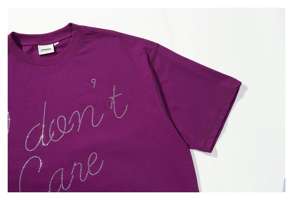 Close-up of the purple T-shirt's short sleeve and rhinestone chest lettering.