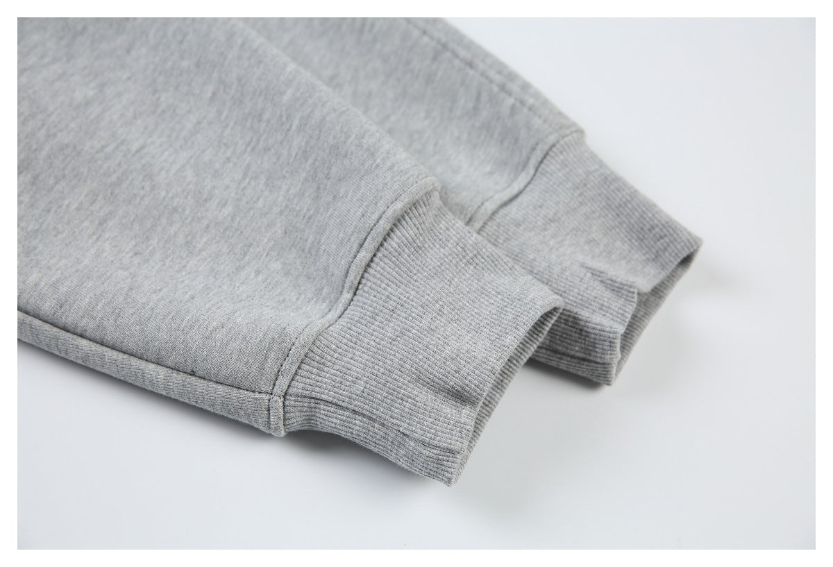 Close-up of two light gray sweatshirt sleeves with ribbed cuffs.