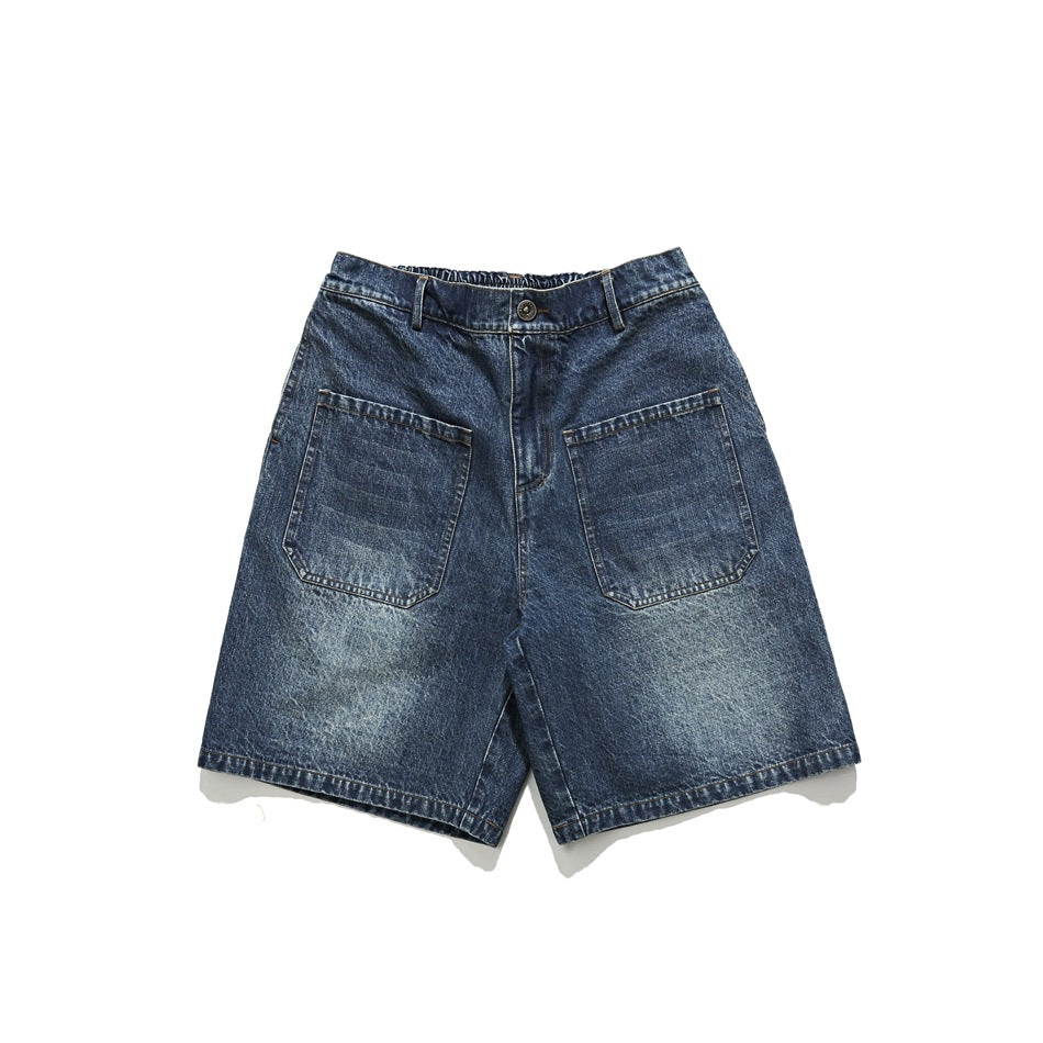 Front view of washed blue denim shorts with two large patch pockets, belt loops and button fly