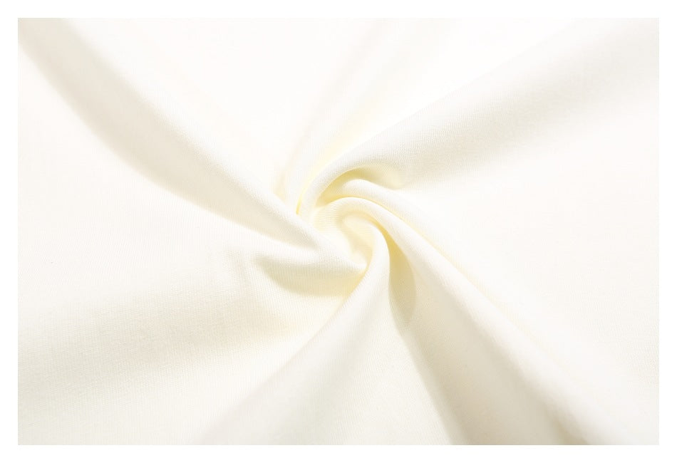 Close-up of the ivory T-shirt fabric, gathered into a soft twist to show its surface.