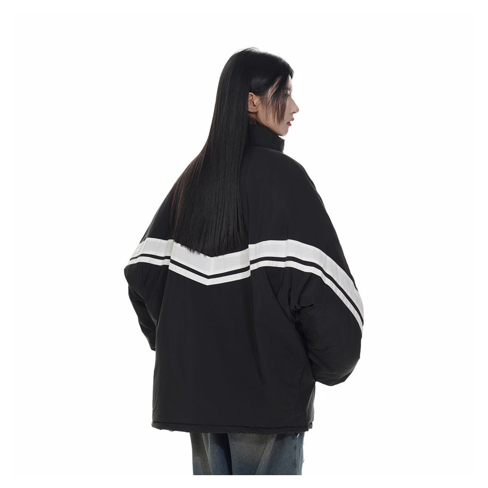 Model showing the back of a black oversized jacket with white chevron stripes.
