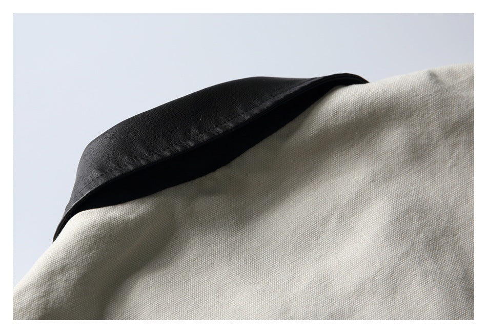 Close-up of a black collar contrasting with light beige textured garment fabric.