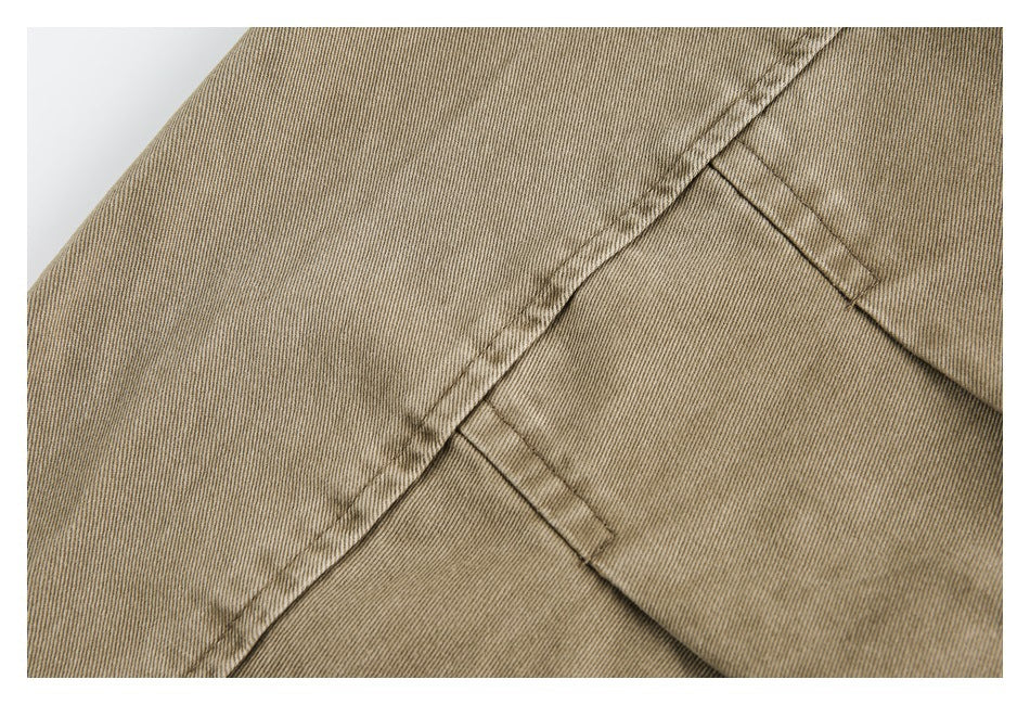 Close-up of tan garment panels with diagonal seams and neat topstitching.