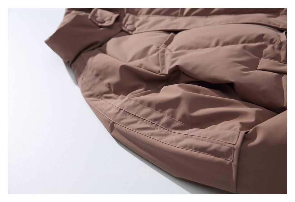 Close-up of a taupe-brown jacket showing a large pocket, flap, and stitched seams.