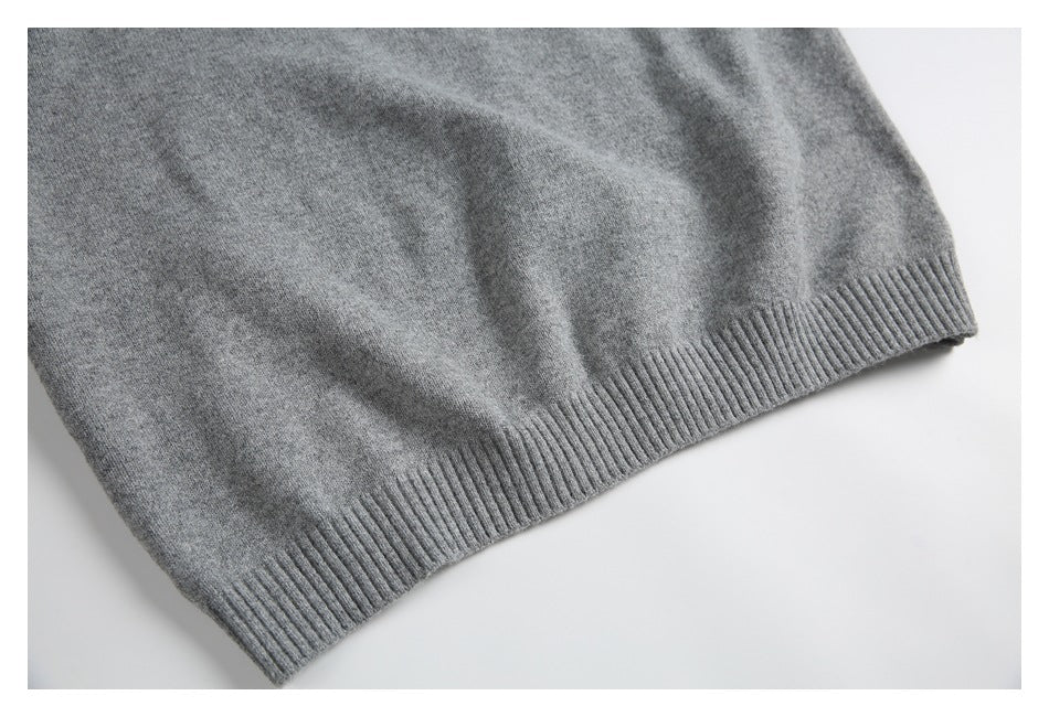 Close-up of the ribbed hem on a gray knit sweater.