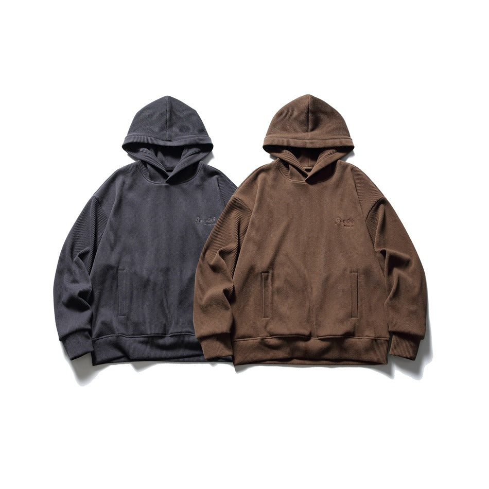 Two pullover hoodies shown from the front in charcoal gray and brown, each with a kangaroo pocket.