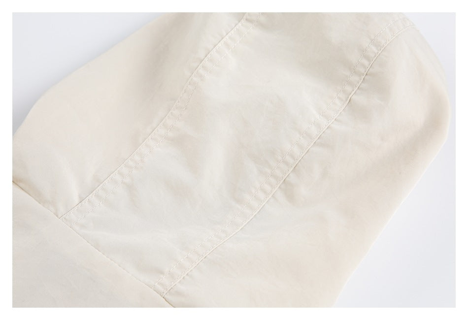 Close-up of a curved double-stitched panel seam on light beige fabric.