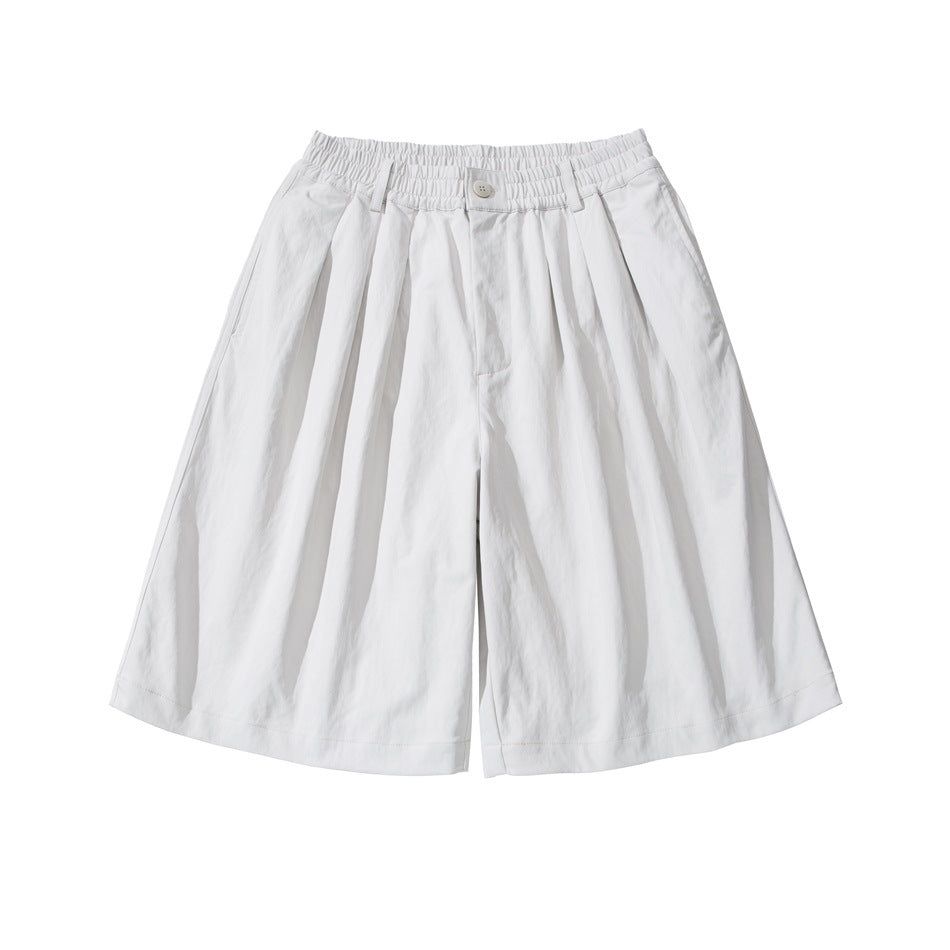 White wide-leg knee-length shorts with front pleats and elastic waistband, flat lay front view