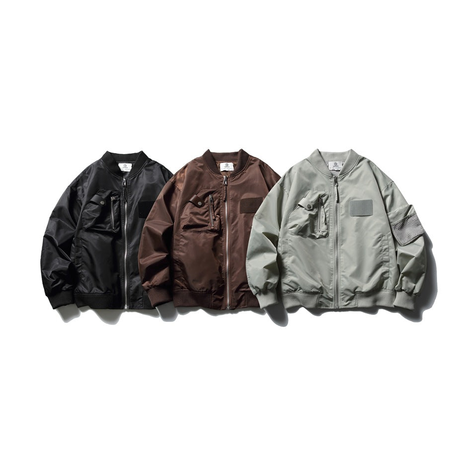 Three front-view bomber jackets in black, dark brown, and pale gray, with ribbed trims and utility pockets.