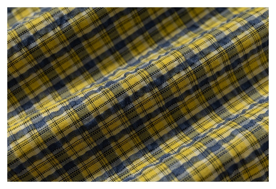 Macro view of the textured yellow and navy plaid fabric.